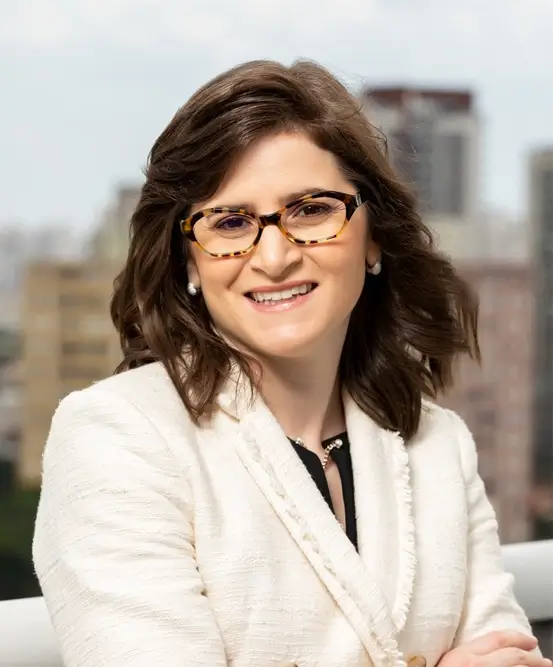 Dra. Iara Debert, oftalmologista infantil e especialista em estrabismo, sorrindo e com olhar acolhedor.