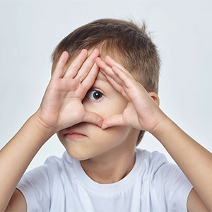 Criança com mãos nos olhos,